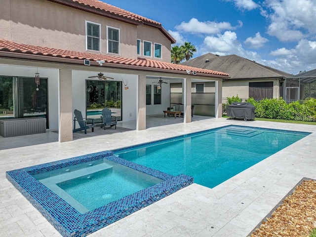 view of swimming pool featuring a patio, ceiling fan, a pool with connected hot tub, and grilling area
