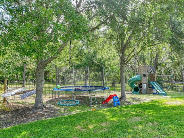 view of yard featuring a playground, fence, and a trampoline