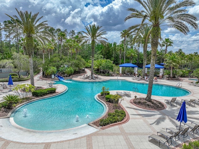pool with a water slide and a patio