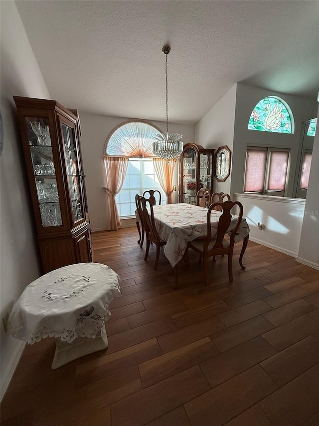 1695 Stable Trl, Palm Harbor, FL 34685 - dining area featuring dark wood-type flooring, a textured ceiling, baseboards, and a chandelier