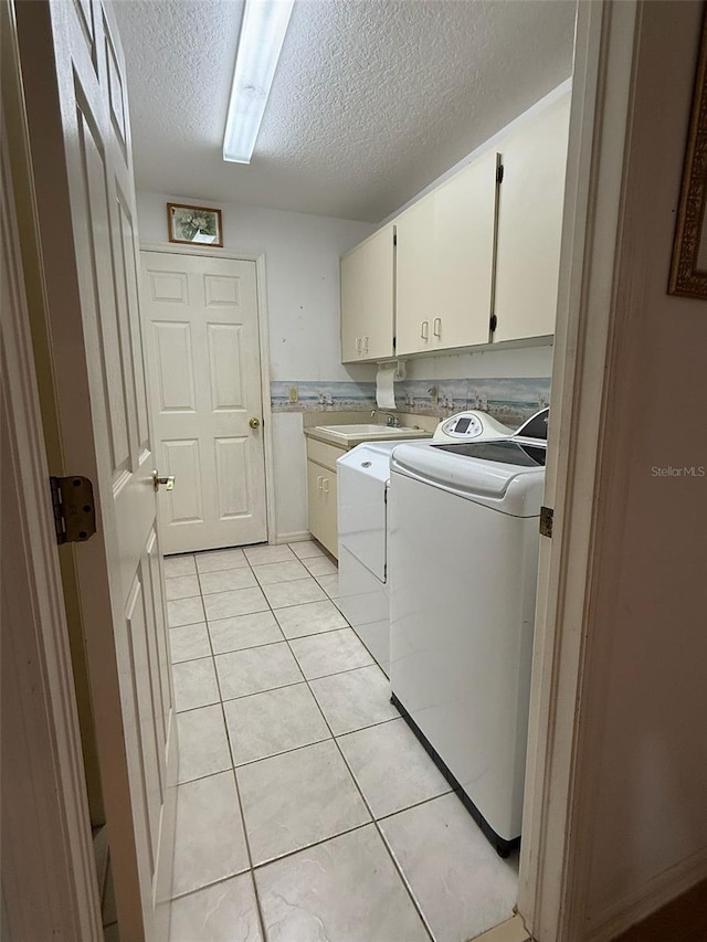 1695 Stable Trl, Palm Harbor, FL 34685 - washroom with cabinet space, light tile patterned flooring, a textured ceiling, and washer and clothes dryer