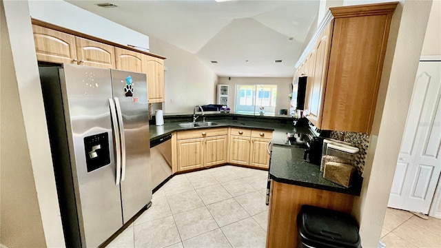 kitchen with dark countertops, appliances with stainless steel finishes, light tile patterned flooring, and light brown cabinets