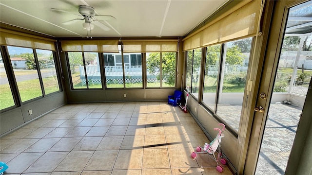 unfurnished sunroom featuring ceiling fan and a wealth of natural light