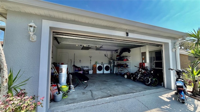 garage featuring washing machine and dryer, water heater, and electric panel