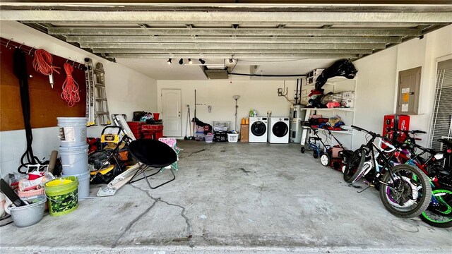 garage featuring washer and dryer, water heater, and electric panel