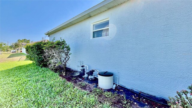 view of side of home with a yard and stucco siding