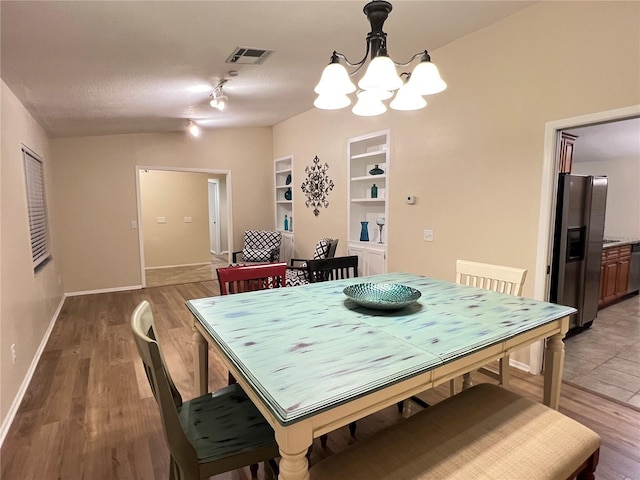 3907 Applegate Cir, Brandon, FL 33511 - dining space featuring a chandelier, light wood-style flooring, and built in shelves