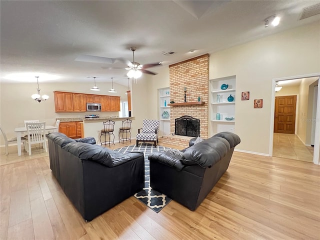3907 Applegate Cir, Brandon, FL 33511 - living room featuring ceiling fan, light wood finished floors, a brick fireplace, and a chandelier