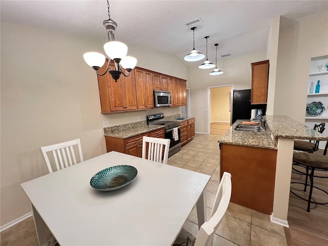 3907 Applegate Cir, Brandon, FL 33511 - kitchen featuring stainless steel appliances, a breakfast bar area, vaulted ceiling, brown cabinets, and a peninsula