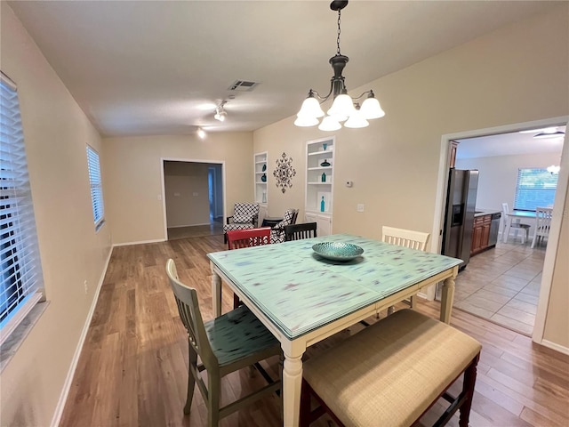 3907 Applegate Cir, Brandon, FL 33511 - dining space with a chandelier, light wood-style floors, and built in shelves
