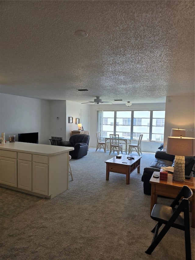 living area with dark carpet, a textured ceiling, and a ceiling fan