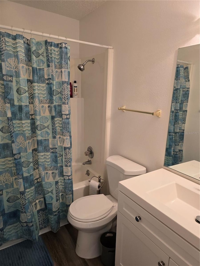 bathroom featuring vanity, a textured ceiling, toilet, shower / bath combo with shower curtain, and wood finished floors