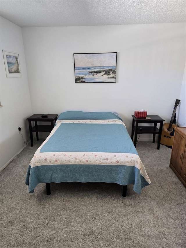 bedroom featuring a textured ceiling and carpet flooring