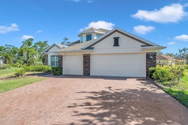view of front of property featuring stucco siding, stone siding, decorative driveway, and an attached garage