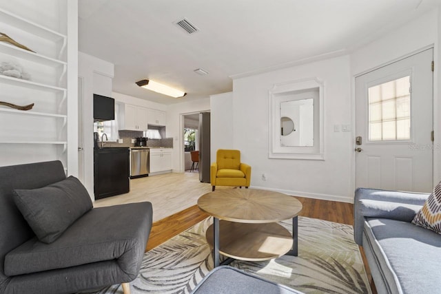 3600 46th St N, Saint Petersburg, FL 33713 - living area with baseboards, visible vents, and light wood-type flooring