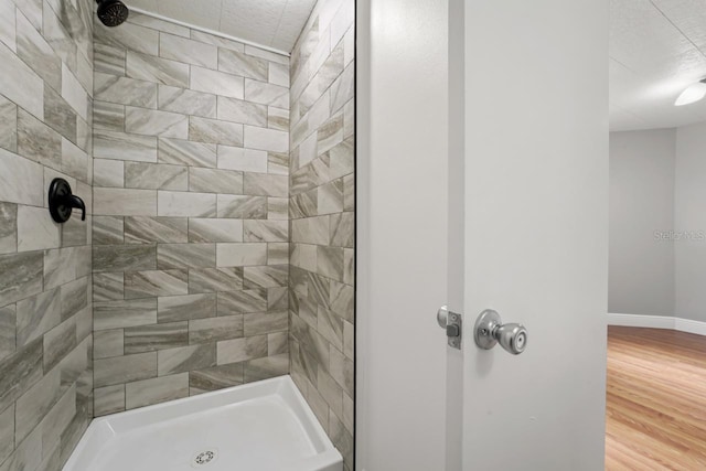 3600 46th St N, Saint Petersburg, FL 33713 - bathroom featuring baseboards, tiled shower, and wood finished floors