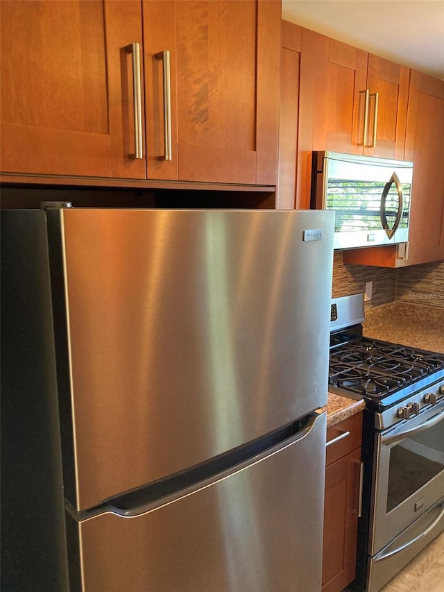kitchen featuring appliances with stainless steel finishes, brown cabinetry, and decorative backsplash