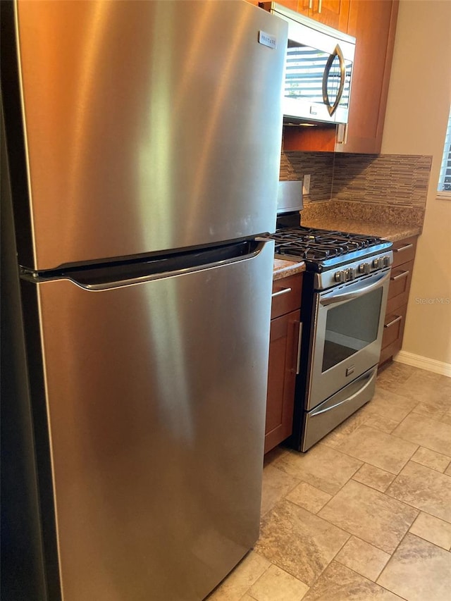 kitchen featuring stainless steel appliances, tasteful backsplash, healthy amount of natural light, and baseboards