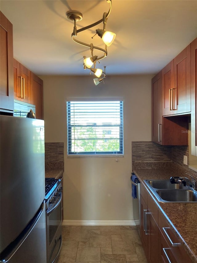 kitchen featuring appliances with stainless steel finishes, a sink, backsplash, and brown cabinetry