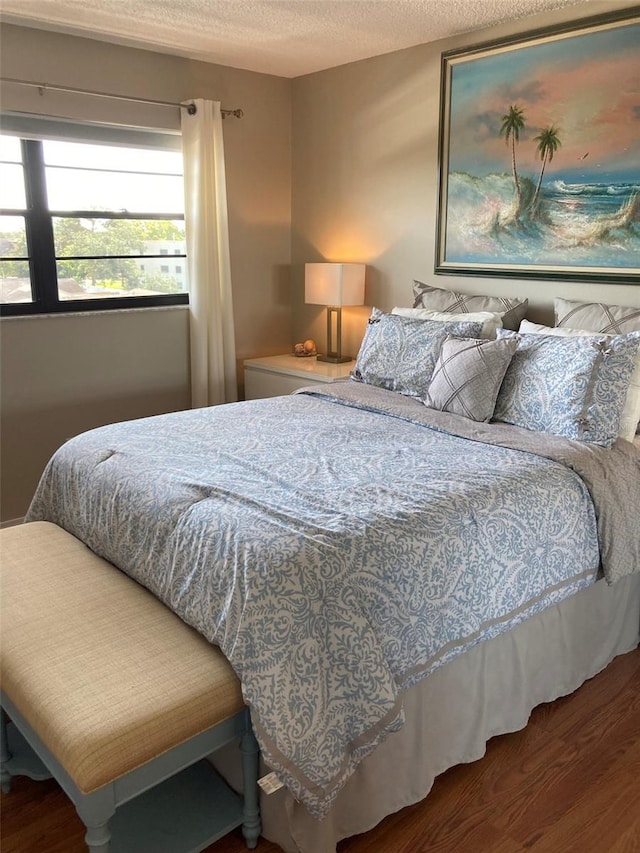 bedroom featuring wood finished floors and a textured ceiling