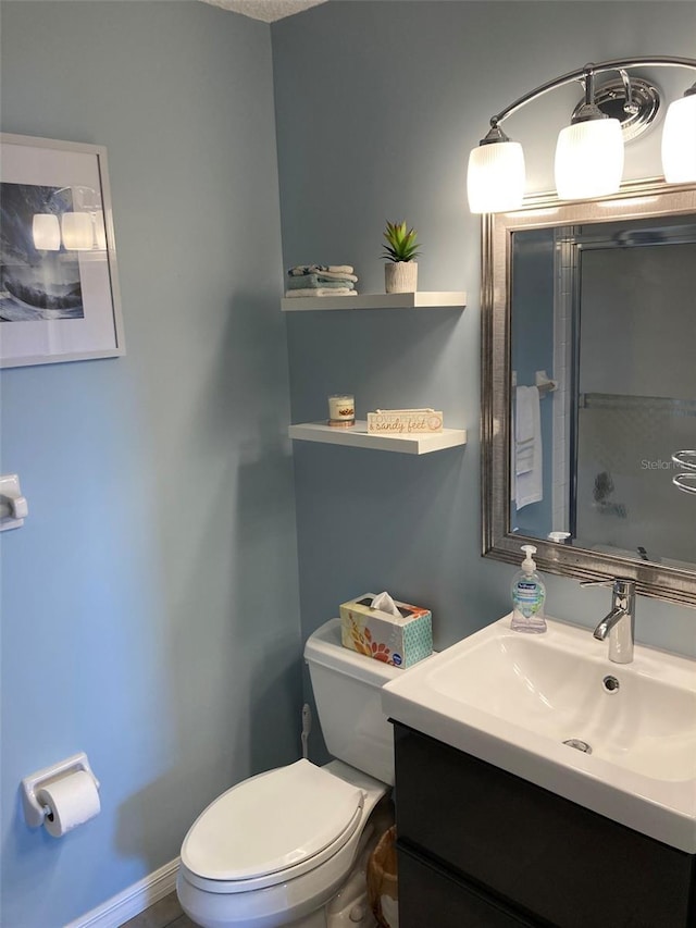 bathroom with toilet, vanity, and baseboards