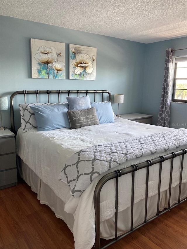 bedroom featuring a textured ceiling and wood finished floors