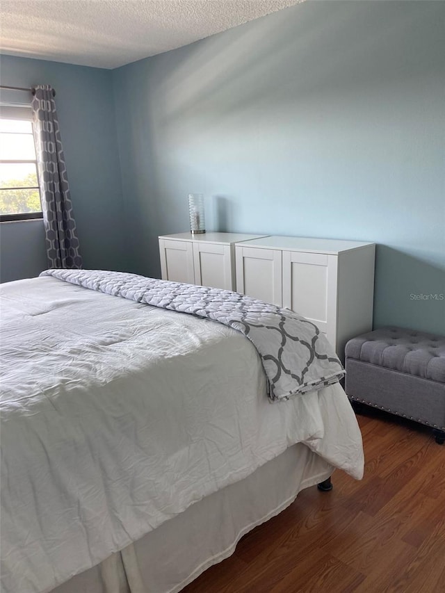 bedroom with wood finished floors and a textured ceiling
