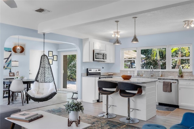 kitchen with white cabinets, visible vents, light wood finished floors, and appliances with stainless steel finishes