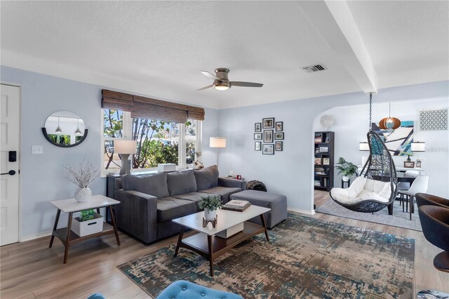 living area with ceiling fan, baseboards, wood finished floors, and visible vents