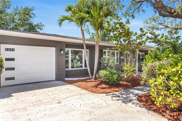 ranch-style house with concrete driveway and an attached garage