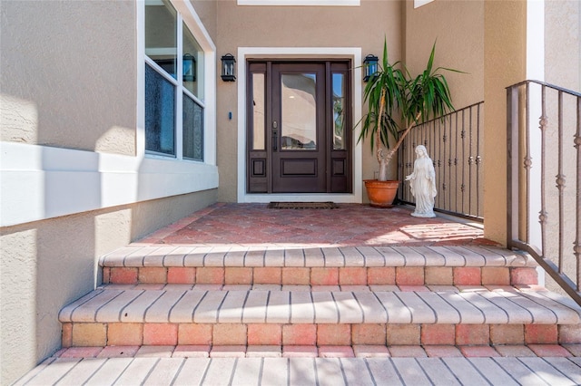 entrance to property featuring stucco siding