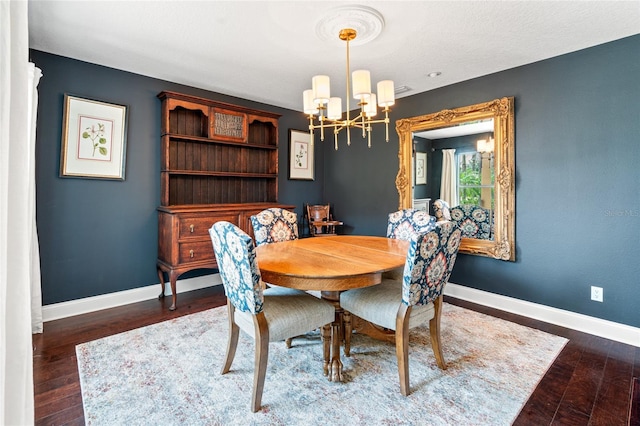 dining room featuring wood finished floors, baseboards, and a notable chandelier