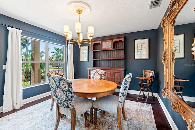 dining area with baseboards, visible vents, a wealth of natural light, and an inviting chandelier