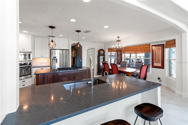 kitchen with a sink, white cabinetry, appliances with stainless steel finishes, visible vents, and recessed lighting