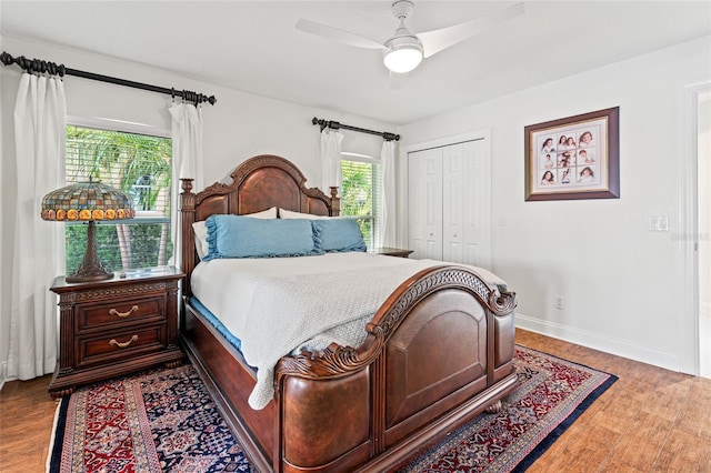 bedroom featuring ceiling fan, baseboards, wood finished floors, and a closet