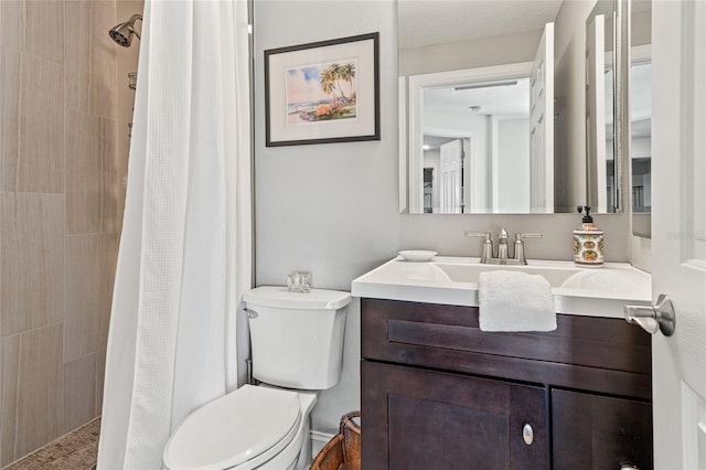 full bath featuring a tile shower, toilet, and vanity