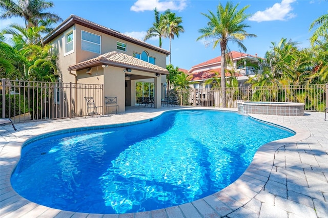 view of pool with fence, ceiling fan, a pool with connected hot tub, and a patio