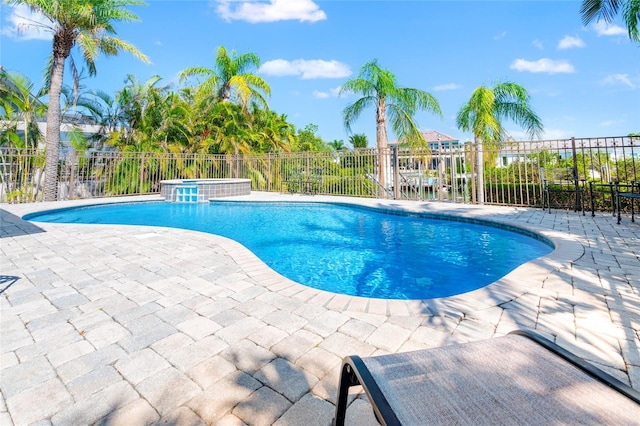 view of swimming pool with fence, a patio area, and a pool with connected hot tub