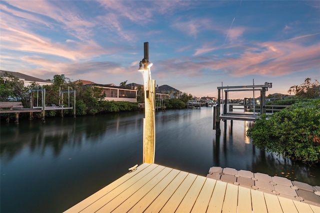 dock area featuring boat lift and a water view