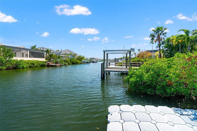 view of dock featuring fence, boat lift, and a water view