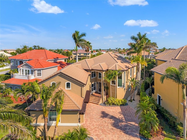 view of front of home with a residential view, a tile roof, stucco siding, and decorative driveway
