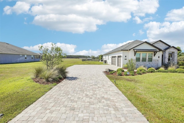 view of front of house featuring an attached garage, a front lawn, stone siding, and decorative driveway