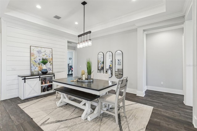 dining space featuring a tray ceiling, dark wood finished floors, crown molding, and recessed lighting