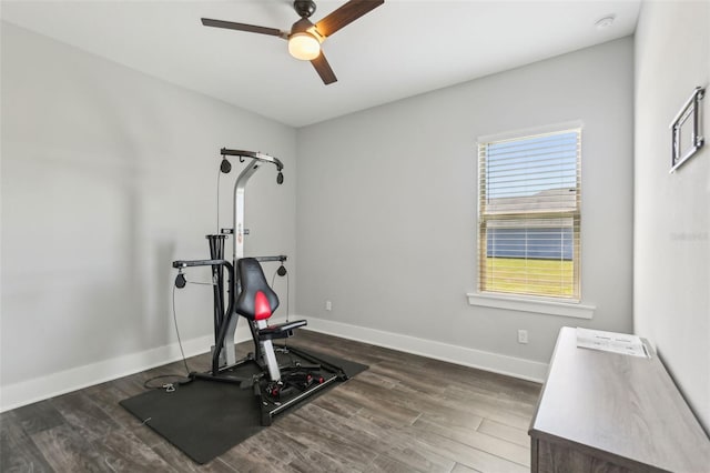 workout area featuring wood finished floors, a ceiling fan, and baseboards