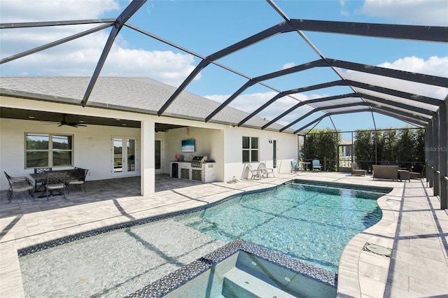 view of pool with ceiling fan, a pool with connected hot tub, exterior kitchen, and a patio