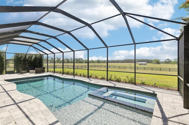 view of swimming pool with a patio area, a rural view, a lawn, a lanai, and a pool with connected hot tub