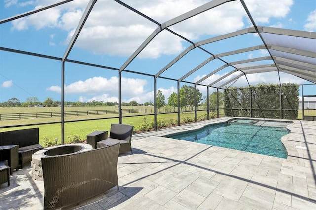 pool featuring a lawn, a lanai, a patio area, and a rural view