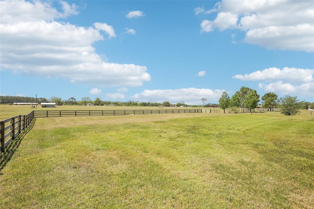 view of yard with fence and a rural view