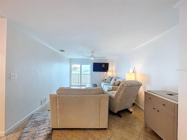 living room with crown molding, baseboards, ceiling fan, and light tile patterned flooring