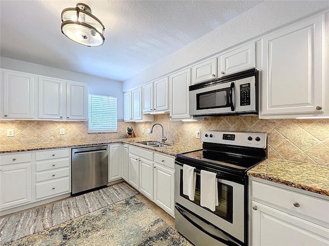 kitchen featuring a sink, appliances with stainless steel finishes, and white cabinets